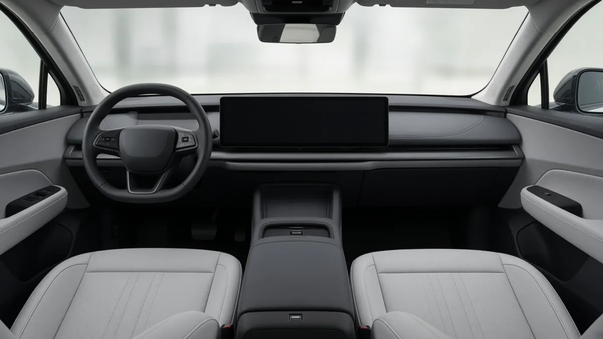 Empty front seats and a blank dark screen in an unbranded electric SUV cabin, with no people